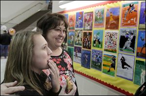 Brianna Kamelesky, 13, left, took a look at some of her fellow students' artwork with art teacher Jennifer Bucher right, during Wednesday evening's 3rd annual Spring Celebration of the Arts at Timberstone Jr. High School in Sylvania.