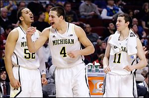 From left, Michigan’s Jordan Morgan, Mitch McGary, and Nik Stauskas celebrate Thursday during their Big Ten tournament win against Penn State.