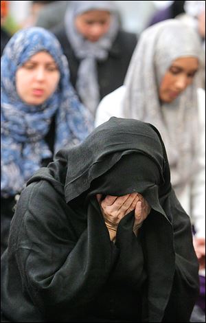 Dr. Farhana Habib of Maumee is overcome with emotion during prayer services at the Islamic Center of Greater Toledo. Friday's services were the first return to the mosque since an arson attack in September.