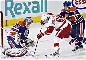 The Red Wings’ Justin Abdelkader, center, is stopped by Edmonton Oilers goalie Devan Dubnyk.