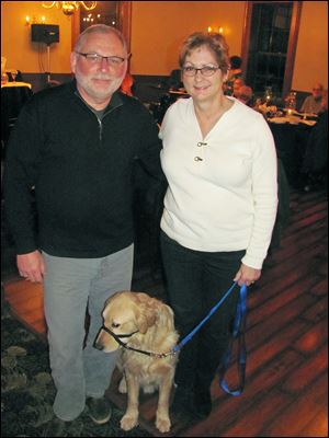 Frank Booth and Gale Tedhams with Murphy, an assistance dog in training.