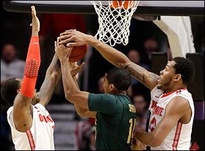 Amir Williams, right, and Deshaun Thomas, left, block a shot by MSU’s Gary Harris in the Buckeyes’ Big Ten semifinal win.