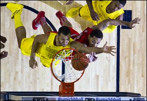 Michigan forward Jon Horford, left, drives to the basket while defended by Ohio State center Amir Williams during their Feb. 5 game at Crisler Center in Ann Arbor. The Buckeyes are a No. 2 seed in the NCAA tournament, while the Wolverines are a No. 4 seed. Both will open the tournament this week in their home states.