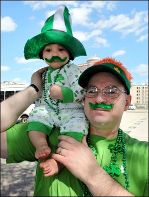 John Palenzuela of Webster, Texas holds his son, Kayden, 6 months old, as they watch the Houston St. Patrick's Day Parade in downtown Houston, Texas Saturday.