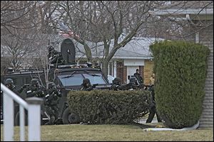 A Special Response Team prepares to enter a home on Kirk Street in Maumee Sunday after a shooting suspect barricaded himself inside. Police entered the home after a five-hour standoff. 