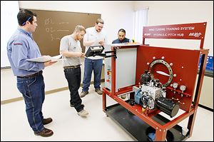 Instructor Nate Eaton, left, watches apprentice electricians David Conner of Woodville, Ohio, John Quist of Adrian, and Matt Taylor of Toledo work on a lesson in the wind turbine certification program at the Toledo Electrical Joint Apprenticeship and Training Committee center in Rossford.