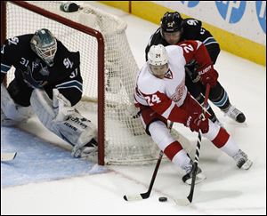 Detroit Red Wings' Damien Brunner drives toward the goal as San Jose Sharks' Matt Irwin, behind, and goalie Antti Niemi defend Thursday in San Jose, Calif.