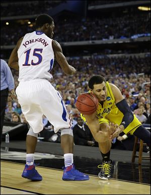 Kansas' Elijah Johnson strips the ball from Michigan's Jordan Morgan during the second half Friday in Arlington, Texas.