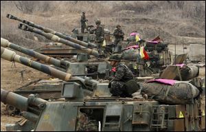 A South Korean marine sits on a K-55 self-propelled howitzer during an exercise against possible attacks by North Korea near the border village of Panmunjom in Paju, South Korea  today.