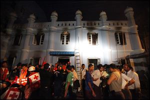 Members of Myanmar Red-Cross team and Muslims gather outside a mosque after a fire broke out early today in Yangon, Myanmar. 