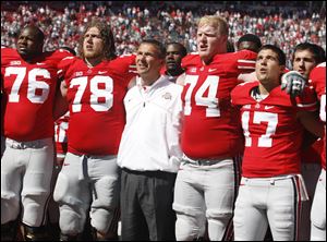 Ohio State offensive lineman Jack Mewhort, 74, joins coach Urban Meyer, and teammates, in the singing of 'Carmen Ohio,' following their game against Central Florida last season at Ohio Stadium in Columbus.