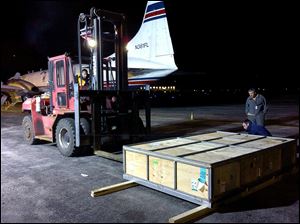 A box containing  a giant saltwater crocodile sits on the tarmac at Toledo Express Airport after it was taken off a cargo plane after arriving Friday night.