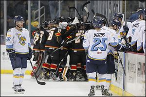 Toledo players Joey Ryan (16) and Ben Youds skate off the ice with their teammates as the Cyclones celebrate.  The Walleye lost to Cincinnati during the second overtime of  Game 1 of an opening round ECHL playoff series at Huntington Center on Friday.