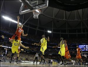 Michigan's Jordan Morgan draws a charge from Syracuse's Brandon Triche late in the game Saturday.