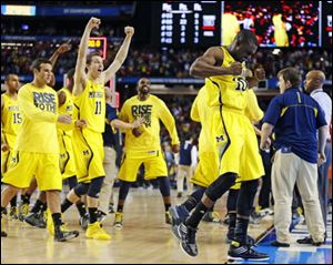 Michigan players including Tim Hardaway Jr., right, and Nik Stauskas (11) celebrate after defeating Syracuse on Saturday in Atlanta.