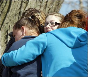 Ruth Brown, center, mother of Viola Francis, is comforted by friends near Sandusky Bay, as the Coast Guard searches for Viola and Jonathan Francis. 