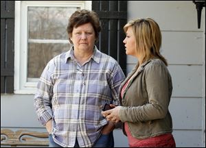 Gwen Gwinner, left, mother of Jonathan Francis, stands with McKallah Back, right, on Mr. Francis' porch on Linwood Avenue.