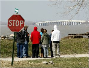 Ruth Brown, center, in a green coat, mother of missing 12-year-old Viola Francis, stands with friends near the edge of the bay on Sandusky's Linwood Avenue, where Viola’s father, Jonathan Francis, lives. 