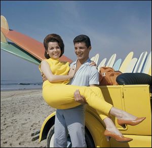 In this 1963 file photo, singer Frankie Avalon and actress Annette Funicello are seen on Malibu Beach during filming of 'Beauty Party' in California in 1963. Former 'Mouseketeer' Funicello died Monday.