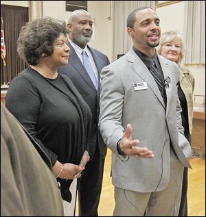 From left, Dr. Cecelia Adams, Larry Sykes, and Lisa Sobecki stand behind Romules Durant after the Board of Education selected Mr. Durant as the interim superintendent of Toledo Public Schools during a meeting Monday at the board’s office.