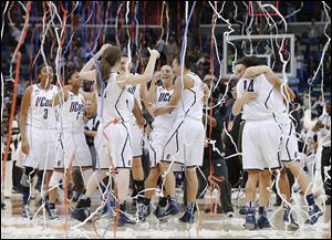 Connecticut players celebrate after defeating Louisville in the women's national championship game.