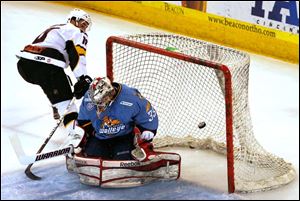 Walleye goalkeeper Kent Simpson blocks down a shot by Cincinnati's Garrett Wilson in the first period.