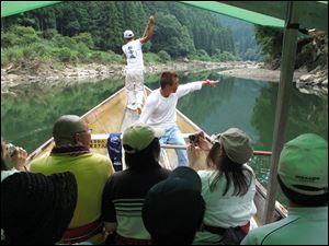 An oarsman pilots an excursion boat down the Hozu River, just outside Kyoto, Japan, as a guide points out sights to his passengers. The two-hour ride offers the chance to spot wildlife while threading rocks and rapids, and is an especially appealing outing for a trip with children.