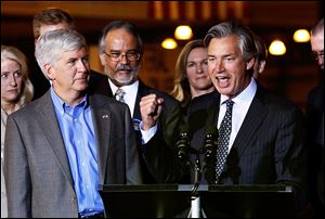 Michigan Gov. Rick Snyder, left, listens as Gary Doer, ambassador of Canada to the United States, announces a key State Department permit to build a second bridge in Detroit linking the United States and Canada.