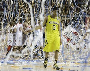 Michigan guard Trey Burke (3) walks off the court as Louisville celebrate their win during the second half of the NCAA Final Four tournament college basketball championship game Monday, April 8, 2013, in Atlanta. Louisville won 82-76. Burke announced today he is foregoing his senior year to declare for the NBA draft.