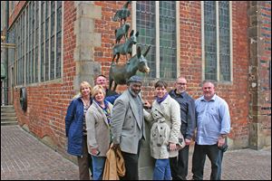 Mayor Mike Bell and his team pose in front of a sculpture near Bremen's St. Peter Cathedral in Bremen. 