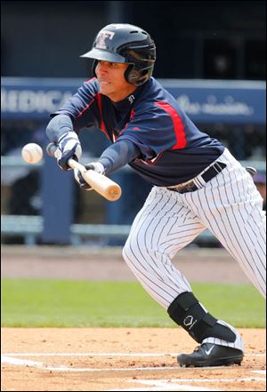 Mud Hens center fielder Quintin Berry lays down a bunt in the first inning. Berry reached first when Tony Cingrani, the Bats' pitcher, couldn't field the ball and make the throw to first. 