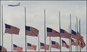 A jetliner flies over flags flying at half-staff at the Washington Monument in Washington after President Obama ordered flags to be lowered on federal building to honor the loss of life from the explosions at the Boston Marathon.