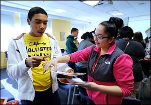 Start High seniors Marcus Johnson and Maria Parraz play a bingo game that aims to get students to learn about one another at the Latino Issues Conference at Bowling Green State University.