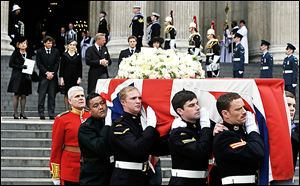 Margaret Thatcher’s family, from left, daughter Carol Thatcher and partner Marco Grass, Sarah Thatcher, wife of son Mark Thatcher, and grandchildren Michael and Amanda Thatcher watch as the coffin is carried away after Wednesday’s funeral.