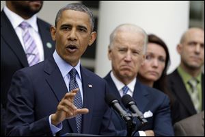 President Barack Obama, next to Vice President Joe Biden, gestures as he speaks during a news conference Wednesday in the Rose Garden of the White House.