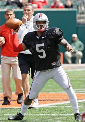 Braxton Miller passes during Ohio State's spring game under the watch of coach Urban Meyer. Miller, who will be a junior, is expected to be a Heisman Trophy favorite next season.