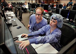 Operating-room man-ager Keith Hanf and Jenni Sheetz, both nurses, enter patient data from binders into a new computerized system at Mercy St. Vincent Medical Center.