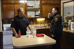 Firefighters Mike Street, left, and Brian Lisowski chat in the temporary Fire Station No. 1 on Brint and McCord roads in Sylvania. The department is using the three-bedroom home, owned by Lourdes University, until construction of the new station in downtown Sylvania is complete. 