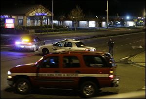 Police and fire vehicles are seen several blocks from the scene of an overnight shooting that police said left five people dead at an apartment complex in Federal Way, Wash.