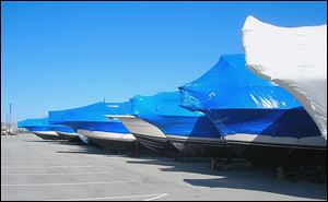 Shrink-wrapped boats sit in storage. The wrap would previously sit in landfills. Now, it is recycled into a material used in guardrails.