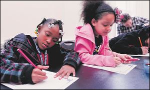 Amaree Slaughter, left, and Yelena Castillo write stories as part of the Farmhouse at Wildwood Metropark in Toledo as part of the Women's Initiative.