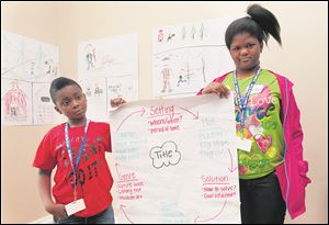 Quantrell Adams, left, and Trinity Crowell hold a chart depicting a method of writing stories.