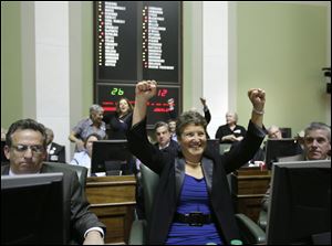 Rhode Island state Sen. Donna Nesselbush, D-Pawtucket, center, reacts seconds after the state senate passed a same-sex marriage bill today at the Statehouse, in Providence, R.I.