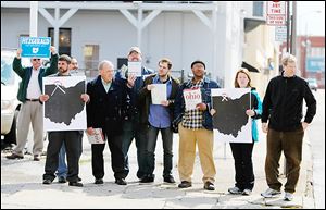 Lucas County Republican Party Chairman Jon Stainbrook, right, and others protest as gubernatorial candidate Ed FitzGerald speaks about his candidacy.