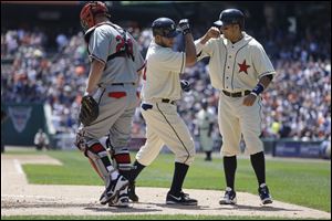 Detroit Tigers' Jhonny Peralta is congratulated by teammate Victor Martinez behind Atlanta Braves catcher Evan Gattis after they both scored on Peralta's two-run home run in the second inning Saturday in Detroit.