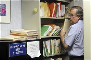 Ted Hole files papers, answers calls, makes appointments, and check in his patients among other duties. The 63-year old doctor has been in practice alone for 34 years.