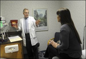 Dr. Ted Hole talks with his patient Cruz Hansen about her allergies.