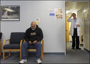 Patient Daniel Drake writes his next appointment in his smart phone at Dr. Ted Hole's office.