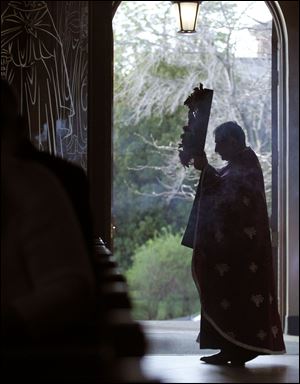 Fr. Aristotle Damaskos walks with an icon during Tuesday's Holy Week service at Holy Trinity Greek Orthodox Cathedral.