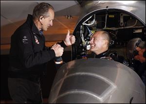 Pilots Bertrand Piccard, right, and André Borschberg, left shake hands before the Solar Impulse plane takes off to embark on a multi-city trip across the United States.